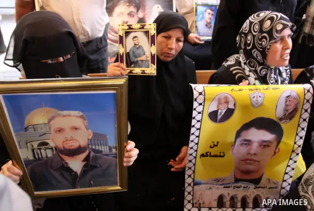 Relatives of Palestinian prisoners eat sweets as they celebrate the upcoming release of Palestinian inmates held in Israeli jails, on Oct. 17, 2011 at the Red Cross' offices in Gaza City. Under a prisoner swap deal signe...