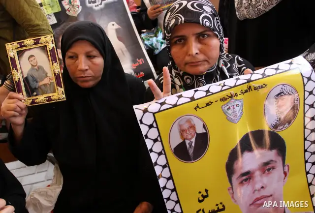 Relatives of Palestinian prisoners eat sweets as they celebrate the upcoming release of Palestinian inmates held in Israeli jails, on Oct. 17, 2011 at the Red Cross' offices in Gaza City. Under a prisoner swap deal signe...