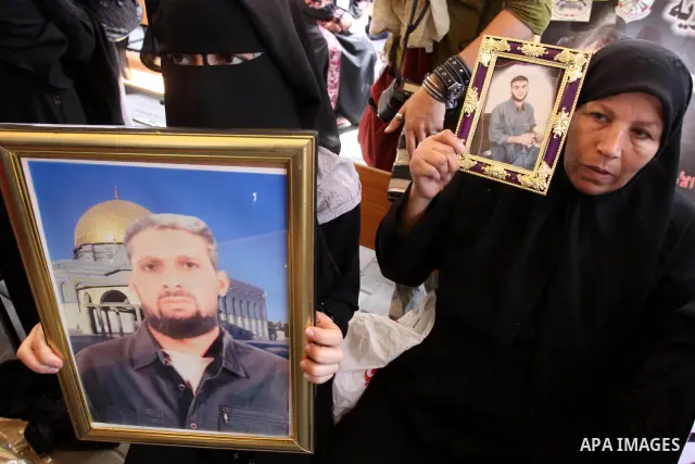 Relatives of Palestinian prisoners eat sweets as they celebrate the upcoming release of Palestinian inmates held in Israeli jails, on Oct. 17, 2011 at the Red Cross' offices in Gaza City. Under a prisoner swap deal signe...
