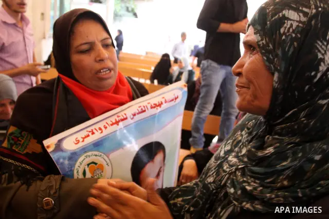 Relatives of Palestinian prisoners eat sweets as they celebrate the upcoming release of Palestinian inmates held in Israeli jails, on Oct. 17, 2011 at the Red Cross' offices in Gaza City. Under a prisoner swap deal signe...