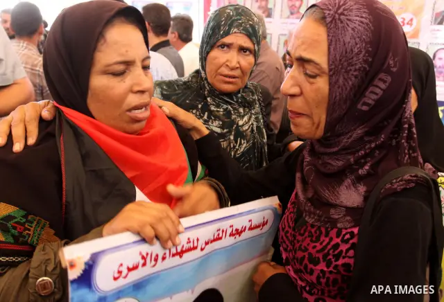 Relatives of Palestinian prisoners eat sweets as they celebrate the upcoming release of Palestinian inmates held in Israeli jails, on Oct. 17, 2011 at the Red Cross' offices in Gaza City. Under a prisoner swap deal signe...