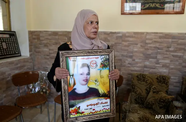 Entesar jayyousi, mother of Palestinian female prisoner doaa jayyousi sentenced to three life sentences in prison Damon , sits next to a photo of her at the family home in the West Bank city of Tulkarem as she reacts to...