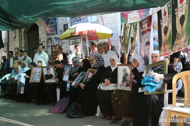 Entesar jayyousi, mother of Palestinian female prisoner doaa jayyousi sentenced to three life sentences in prison Damon , sits next to a photo of her at the family home in the West Bank city of Tulkarem as she reacts to...