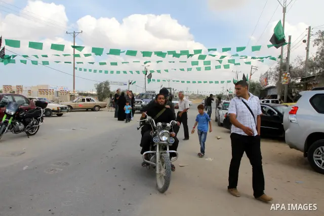Palestinians gather at the Rafah border crossing in the southern Gaza Strip October 17, 2011, during preparations for the release of prisoners in a swap that is expected to take place on Tuesday. Hamas prepared a heroes'...