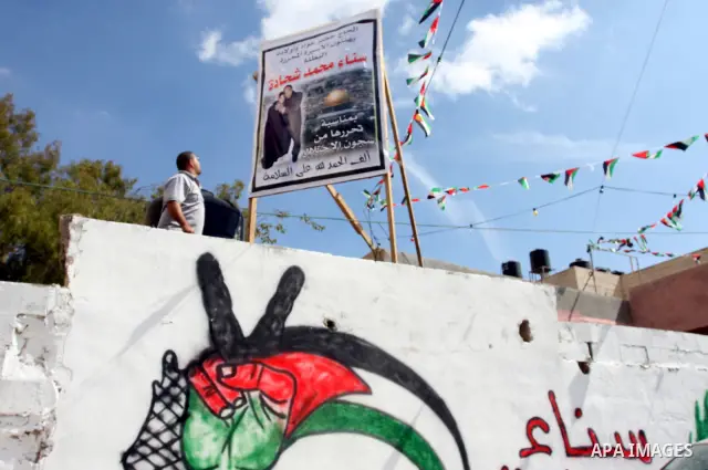 Palestinians decorate a building ahead of the release of Sana'a Shahada shown in banner, in the West Bank city of Ramallah, Monday, Oct. 17, 2011. Shahada is scheduled to be released on Tuesday in an exchange between Isr...