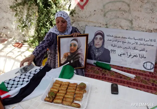 Palestinians decorate a building ahead of the release of Sana'a Shahada shown in banner, in the West Bank city of Ramallah, Monday, Oct. 17, 2011. Shahada is scheduled to be released on Tuesday in an exchange between Isr...