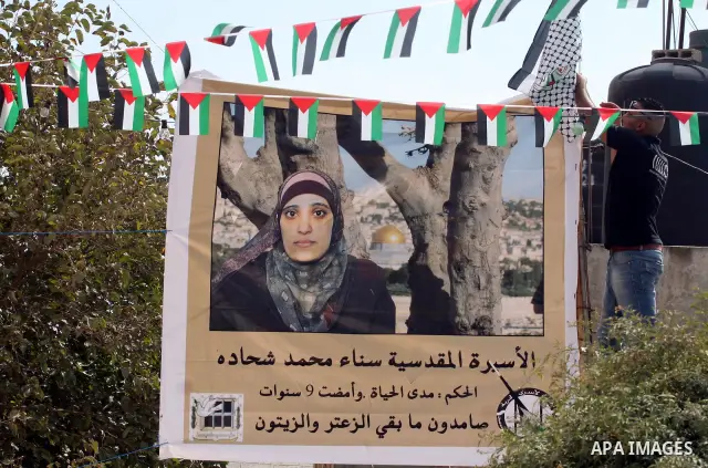 Palestinians decorate a building ahead of the release of Sana'a Shahada shown in banner, in the West Bank city of Ramallah, Monday, Oct. 17, 2011. Shahada is scheduled to be released on Tuesday in an exchange between Isr...