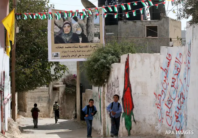 Palestinians decorate a building ahead of the release of Sana'a Shahada shown in banner, in the West Bank city of Ramallah, Monday, Oct. 17, 2011. Shahada is scheduled to be released on Tuesday in an exchange between Isr...