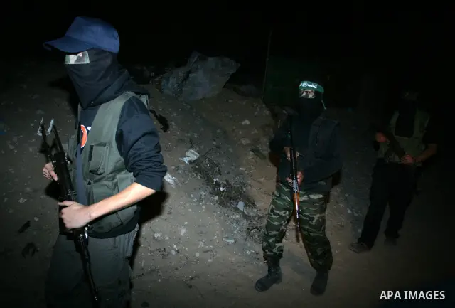 Palestinian Hamas militants stand guard on the main road in Khan Younis, southern Gaza Strip, Monday, Oct. 17, 2011. The exchange between Israel and Hamas in which 1,027 Palestinian prisoners will be released for capture...