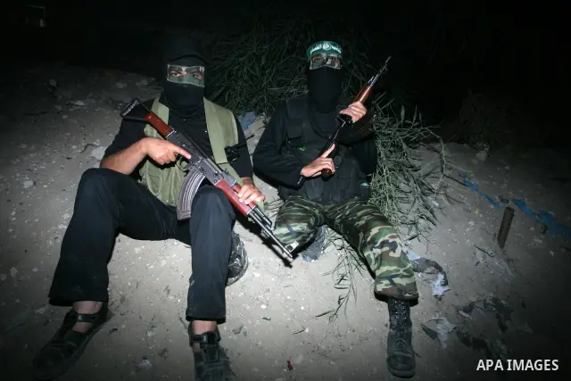 Palestinian Hamas militants stand guard on the main road in Khan Younis, southern Gaza Strip, Monday, Oct. 17, 2011. The exchange between Israel and Hamas in which 1,027 Palestinian prisoners will be released for capture...
