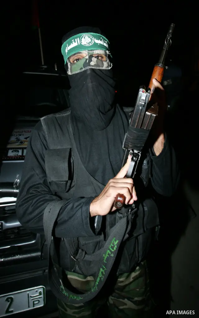 Palestinian Hamas militants stand guard on the main road in Khan Younis, southern Gaza Strip, Monday, Oct. 17, 2011. The exchange between Israel and Hamas in which 1,027 Palestinian prisoners will be released for capture...
