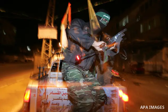 Palestinian Hamas militants stand guard on the main road in Khan Younis, southern Gaza Strip, Monday, Oct. 17, 2011. The exchange between Israel and Hamas in which 1,027 Palestinian prisoners will be released for capture...