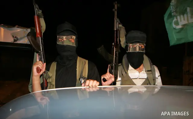 Palestinian Hamas militants stand guard on the main road in Khan Younis, southern Gaza Strip, Monday, Oct. 17, 2011. The exchange between Israel and Hamas in which 1,027 Palestinian prisoners will be released for capture...