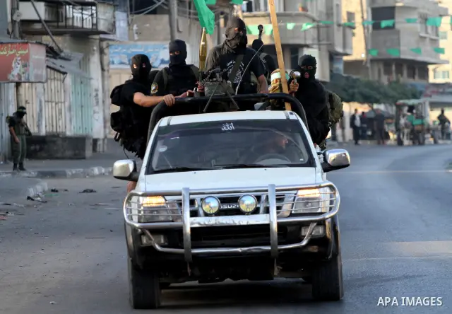 Armed Palestinian Hamas militants stand guard at a street in Gaza city on October 18, 2011 as an Israeli-Palestinian prisoner swap deal gets under way. Buses carrying 477 Palestinian prisoners were headed for Gaza and th...