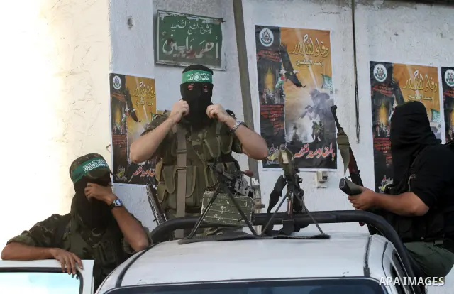 Armed Palestinian Hamas militants stand guard at a street in Gaza city on October 18, 2011 as an Israeli-Palestinian prisoner swap deal gets under way. Buses carrying 477 Palestinian prisoners were headed for Gaza and th...