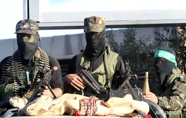 Armed Palestinian Hamas militants stand guard at a street in Gaza city on October 18, 2011 as an Israeli-Palestinian prisoner swap deal gets under way. Buses carrying 477 Palestinian prisoners were headed for Gaza and th...