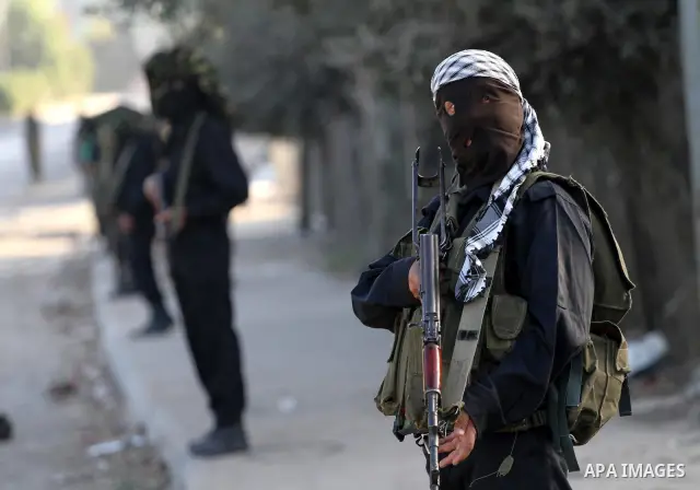 Armed Palestinian Hamas militants stand guard at a street in Gaza city on October 18, 2011 as an Israeli-Palestinian prisoner swap deal gets under way. Buses carrying 477 Palestinian prisoners were headed for Gaza and th...
