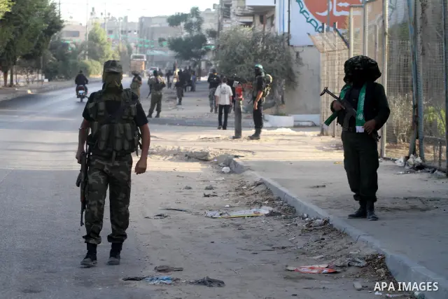 Armed Palestinian Hamas militants stand guard at a street in Gaza city on October 18, 2011 as an Israeli-Palestinian prisoner swap deal gets under way. Buses carrying 477 Palestinian prisoners were headed for Gaza and th...