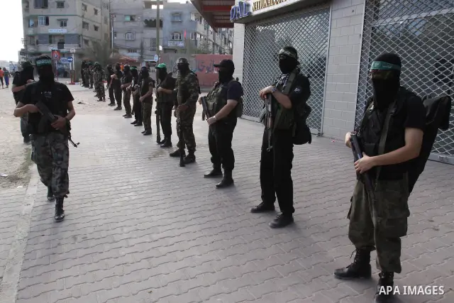 Armed Palestinian Hamas militants stand guard at a street in Gaza city on October 18, 2011 as an Israeli-Palestinian prisoner swap deal gets under way. Buses carrying 477 Palestinian prisoners were headed for Gaza and th...