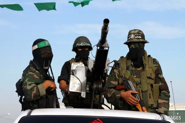 Armed Palestinian Hamas militants keep watch near the Rafah crossing with Egypt in the southern Gaza Strip on October 18, 2011 as an Israeli-Palestinian prisoner swap deal gets under way. Buses carrying 477 Palestinian p...