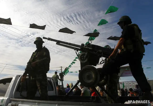 Armed Palestinian Hamas militants keep watch near the Rafah crossing with Egypt in the southern Gaza Strip on October 18, 2011 as an Israeli-Palestinian prisoner swap deal gets under way. Buses carrying 477 Palestinian p...