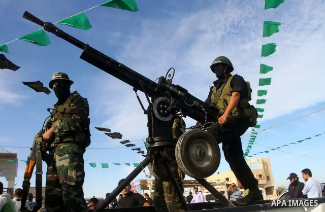 Armed Palestinian Hamas militants keep watch near the Rafah crossing with Egypt in the southern Gaza Strip on October 18, 2011 as an Israeli-Palestinian prisoner swap deal gets under way. Buses carrying 477 Palestinian p...