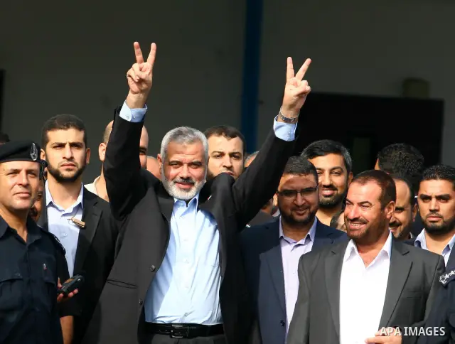 Palestinian Prime Minister in Gaza Strip, Ismail Haniya waves to his supporters during his arrival to Rafah crossing with Egypt in the southern Gaza Strip on October 18, 2011 as an Israeli-Palestinian prisoner swap deal...