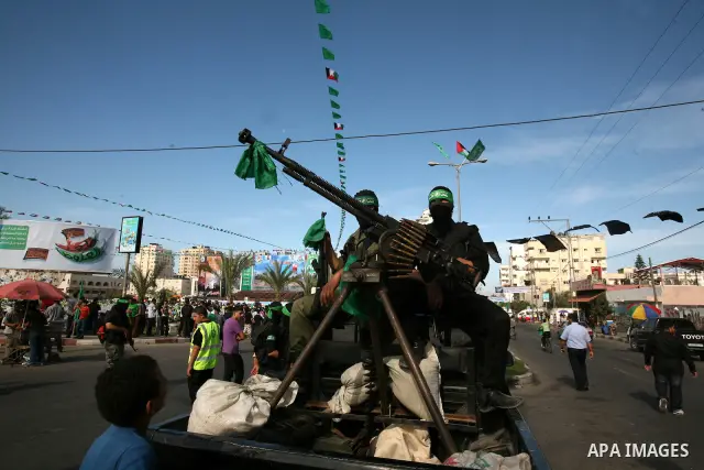 Palestinians keep watch as Hamas militants stand guard in Gaza City on October 18, 2011 as an Israeli-Palestinian prisoner swap deal gets under way. Captive Israeli soldier Gilad Shalit was today freed from five years of...