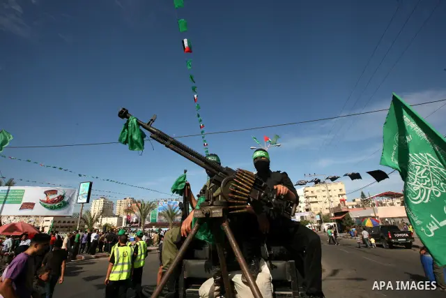 Palestinians keep watch as Hamas militants stand guard in Gaza City on October 18, 2011 as an Israeli-Palestinian prisoner swap deal gets under way. Captive Israeli soldier Gilad Shalit was today freed from five years of...
