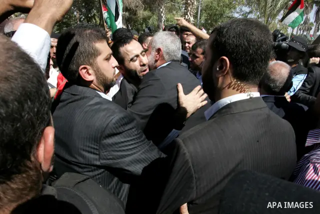 Palestinian Prime Minister in Gaza Strip, Ismail Haniyeh greets a released Palestinian prisoner at the Rafah border crossing in southern Gaza Strip, Tuesday, Oct. 18, 2011. The Hamas militant group released an Israeli so...