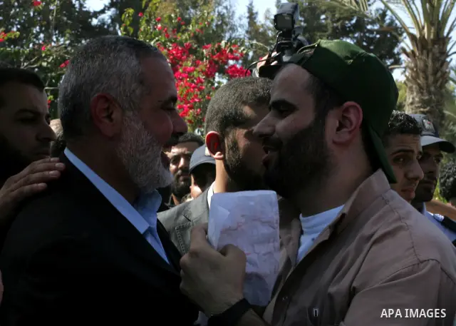 Palestinian Prime Minister in Gaza Strip, Ismail Haniyeh greets a released Palestinian prisoner at the Rafah border crossing in southern Gaza Strip, Tuesday, Oct. 18, 2011. The Hamas militant group released an Israeli so...