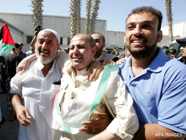 Palestinians greet their relative released Palestinian prisoner at the Rafah border crossing in southern Gaza Strip, Tuesday, Oct. 18, 2011. The Hamas militant group released an Israeli soldier Tuesday more than five yea...