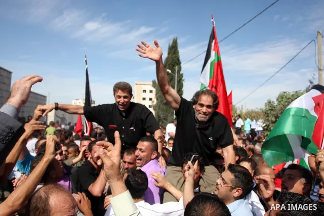 A Palestinian prisoner is welcomed by a crowd following the release of hundreds of prisoners from Israeli jails on October 18,2011 at the Palestinian Authority headquarters in the West Bank city of Ramallah. Crowds of Pa...