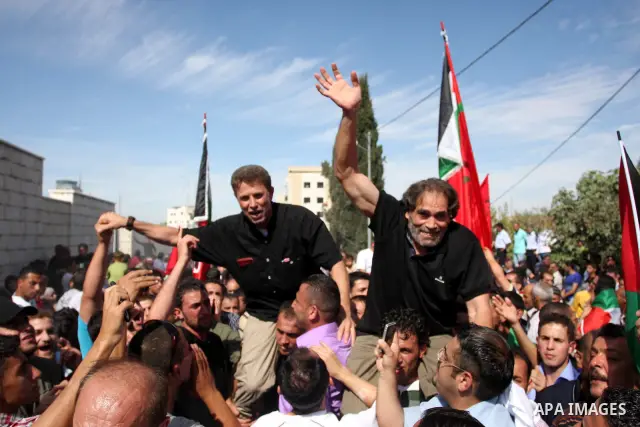 A Palestinian prisoner is welcomed by a crowd following the release of hundreds of prisoners from Israeli jails on October 18,2011 at the Palestinian Authority headquarters in the West Bank city of Ramallah. Crowds of Pa...