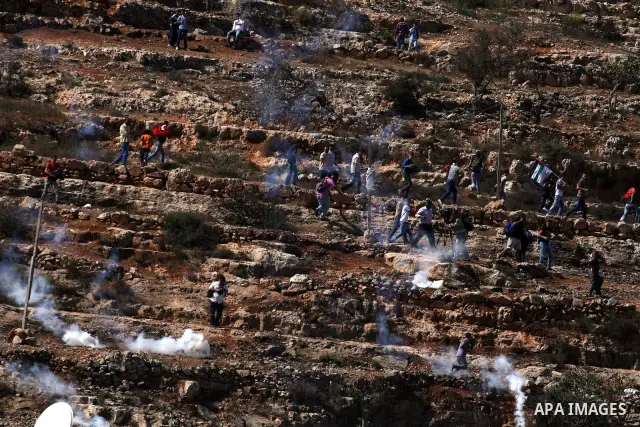 Palestinians run to take cover from tear gas fired by Israeli troops while they wait for released prisoners outside the Ofer prison near the West Bank city of Ramallah on Oct. 18, 2011. Hamas and Israel reached a prison...