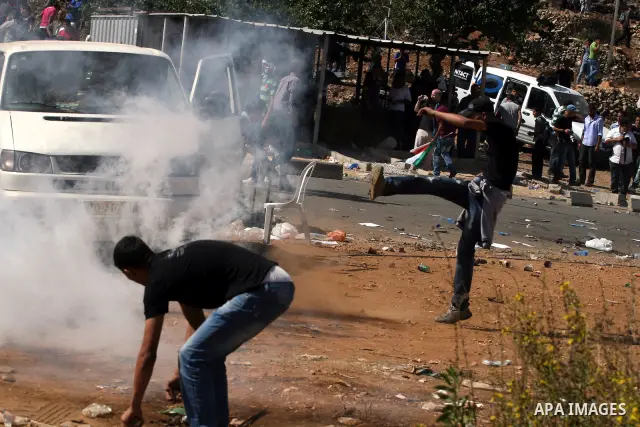 Palestinians run to take cover from tear gas fired by Israeli troops while they wait for released prisoners outside the Ofer prison near the West Bank city of Ramallah on Oct. 18, 2011. Hamas and Israel reached a prison...