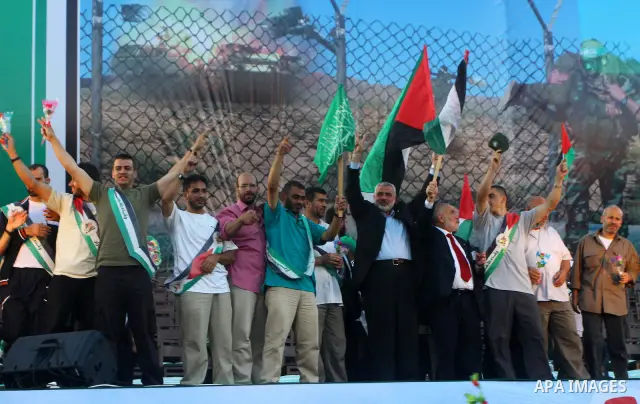 Palestinian Prime Minister in Gaza Strip, Ismail Haniyeh stands with released Palestinian prisoner among others as they celebrate during a welcoming ceremony, in Gaza City, Tuesday, Oct. 18, 2011. Hamas agreed to release...