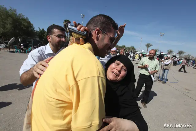 Palestinians greet their relative released Palestinian prisoner at the Rafah border crossing in southern Gaza Strip, Tuesday, Oct. 18, 2011. The Hamas militant group released an Israeli soldier Tuesday more than five yea...