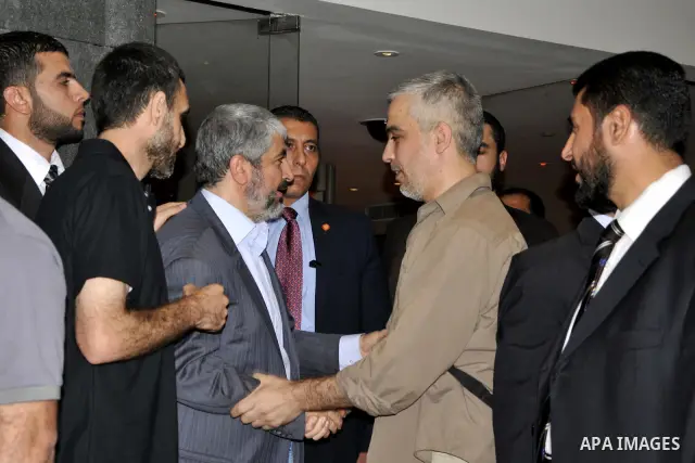 Hamas political leader Khaled Meshal, left, greets a Palestinian released prisoner upon his arrival in Cairo, Egypt, Tuesday, Oct.18, 2011 .Hundreds of Palestinians freed from Israeli prisons in exchange for the release...