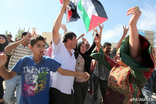 Palestinian prisoners are welcomed by a crowd following the release of hundreds of prisoners from Israeli jails on October 18,2011 at the Palestinian Authority headquarters in the West Bank city of Ramallah. Crowds of Pa...