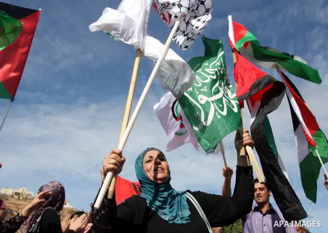Palestinians wait at the Beituniya checkpoint for released Palestinian prisoners to cross into the West Bank city of Ramallah, Tuesday, Oct. 18, 2011. The Hamas militant group released an Israeli soldier Tuesday more tha...
