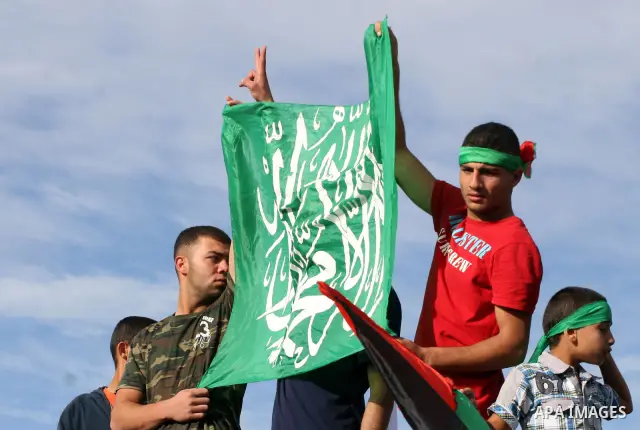 Palestinians wait at the Beituniya checkpoint for released Palestinian prisoners to cross into the West Bank city of Ramallah, Tuesday, Oct. 18, 2011. The Hamas militant group released an Israeli soldier Tuesday more tha...