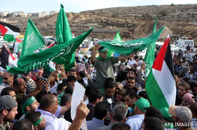 Palestinians wait at the Beituniya checkpoint for released Palestinian prisoners to cross into the West Bank city of Ramallah, Tuesday, Oct. 18, 2011. The Hamas militant group released an Israeli soldier Tuesday more tha...