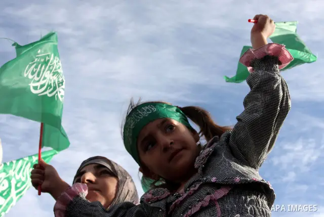 Palestinians wait at the Beituniya checkpoint for released Palestinian prisoners to cross into the West Bank city of Ramallah, Tuesday, Oct. 18, 2011. The Hamas militant group released an Israeli soldier Tuesday more tha...