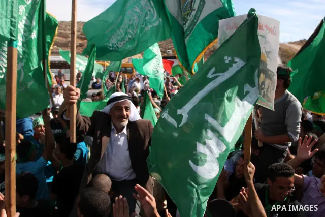 Palestinians wait at the Beituniya checkpoint for released Palestinian prisoners to cross into the West Bank city of Ramallah, Tuesday, Oct. 18, 2011. The Hamas militant group released an Israeli soldier Tuesday more tha...
