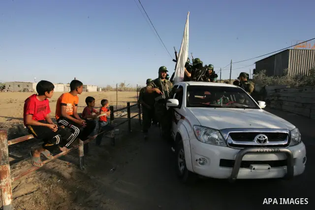 Hamas militants pray before going to pay their respects to freed Palestinian prisoners in Rafah, southern Gaza Strip, Wednesday, Oct. 19, 2011. Tens of thousands of flag-waving Palestinians celebrated the homecoming of h...