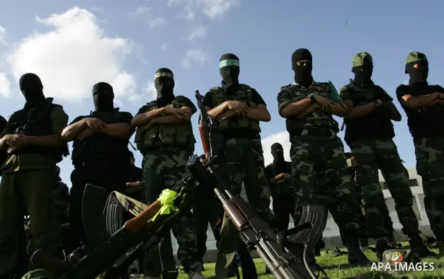 Hamas militants pray before going to pay their respects to freed Palestinian prisoners in Rafah, southern Gaza Strip, Wednesday, Oct. 19, 2011. Tens of thousands of flag-waving Palestinians celebrated the homecoming of h...