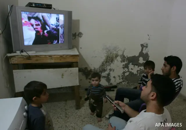 Palestinians watch television news the killing of the Libyan leader,in their home in a refugee camp in Rafah, southern Gaza Strip on October 20, 2011. Head of the military in the city of Tripoli, "Abdel Hakim Belhadj, "...