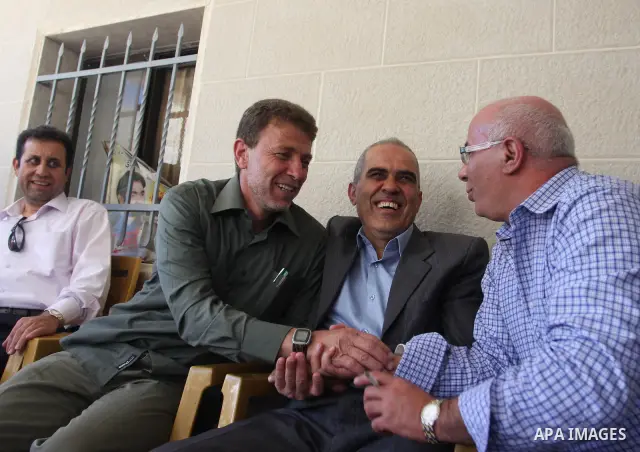 Freed Palestinian prisoner Nael Barghoutia, 53,who served 33 years in jail, more time than any other Palestinian released in a trade for Israeli soldier Gilad Shalit, greets a child along with Fakhri Barghoutia 54 years,...