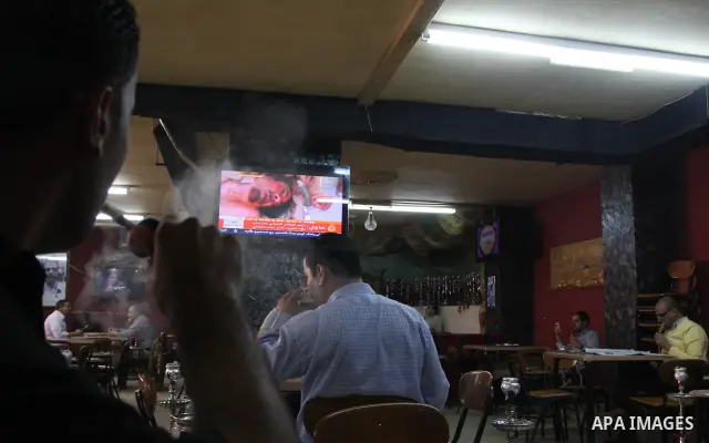 Palestinians watch television news the killing of the Libyan leader,in West Bank, City of Ramallah, on October 20, 2011. Head of the military in the city of Tripoli, "Abdel Hakim Belhadj, " the killing of Libyan leader o...